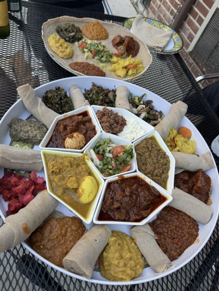 A grand Ethiopian sharing platter with injera rolls and an array of stews